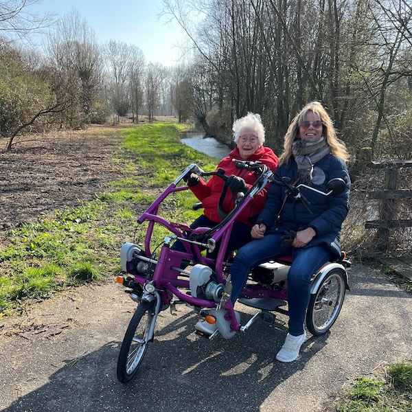 Vrijwilliger met hulpvrager op de duofiets de natuur in
