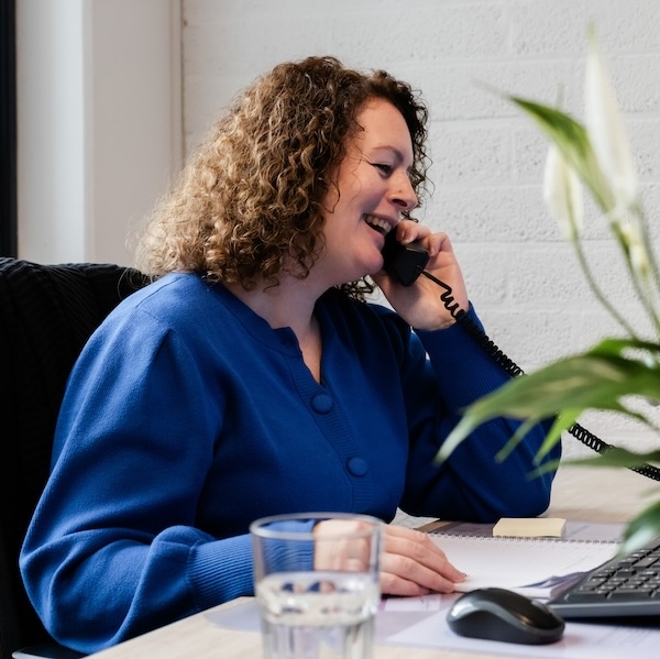 Een medewerker van de Algemene Hulpdienst Nieuwegein aan de telefoon